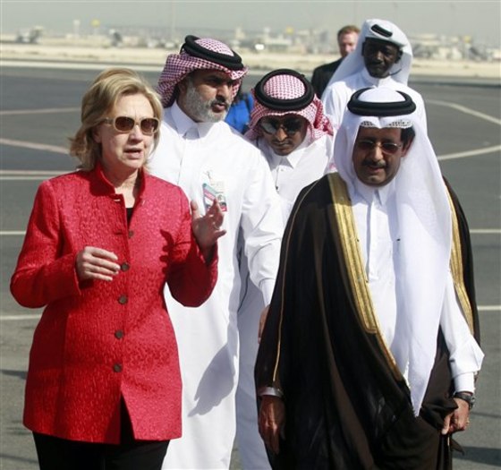 Secretary of State Hillary Clinton, left, is welcomed by the Qatari Ambassador to U.S. Ali Al Hajri, right, at the Doha International Airport in Doha, Qatar, on Sunday. Clinton is holding talks with top government leaders and speaking at an international conference called the U.S.-Islamic World Forum.